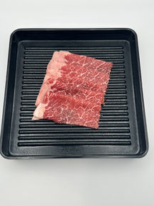 Raw marbled beef on a black tray