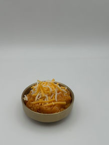 Bowl of mashed sweet potatoes with shredded cheese