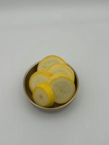 Round slices of yellow squash in a small bowl