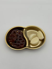 Dried lotus root and garlic cloves in a gold dish