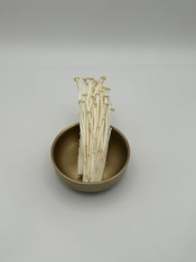 Enoki mushrooms in a bronze bowl