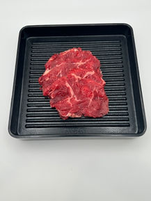 Raw beef slices on a black ribbed tray