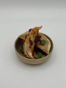 Pan-fried dumplings with chili oil and green onions