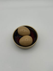 Two marinated eggs in a bowl