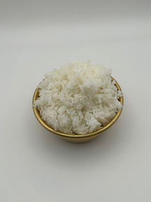 Shredded coconut flakes in a golden bowl